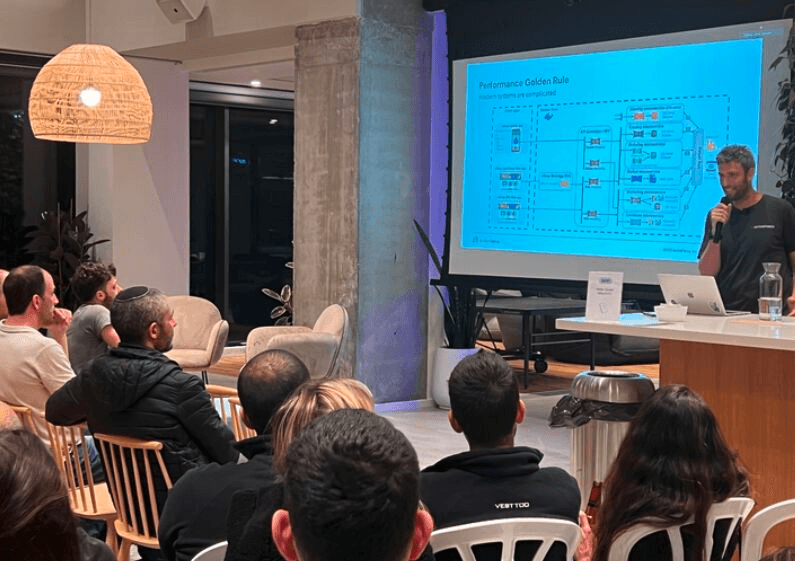 Ziv on stage explaining the performance golden rule to meetup attendees in Israel